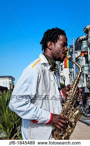 Stock Photo - Black man playing sax in Gay Pride Weekend Pink Celebration in the gay Castro District of San Francisco California. Fotosearch