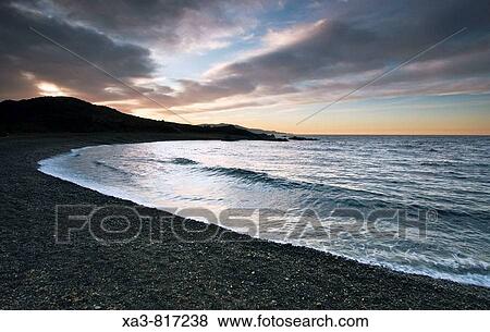 Black volcanic stone beach at sunset, Almeria province, Andalusia, Spain View Large Photo Image Stock Photo - Black volcanic stone beach at sunset, Almeria province, Andalusia, Spain. Fotosearch