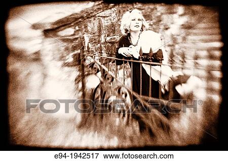Black & white portrait of a 34 year old blond woman looking at the camera standing by an iron fence. View Large Photo Image Stock Photo - Black & white portrait of a 34 year old blond woman looking at the camera standing by an iron fence.. Fotosearch