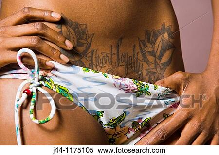 Stock Photography - Black woman in swimming suit with a tattoo, Close up. Fotosearch
