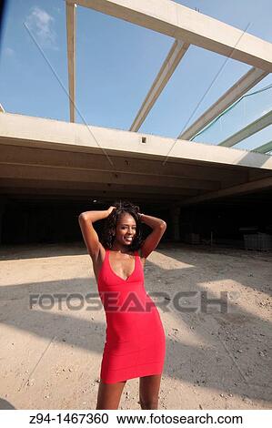 Stock Image - Black woman wearing a red dress. Fotosearch