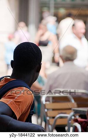 Black young man looking at white people in downtown, Valencia city, Spain View Large Photo Image Stock Image - Black young man looking at white people in downtown, Valencia city, Spain. Fotosearch