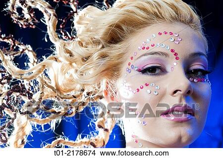 Picture - blond girl with fancy hairstyle and makeup.. Fotosearch