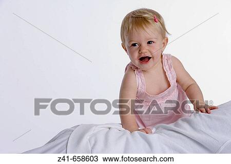 Blond little girl climbing on her mothers legs View Large Photo Image Stock Image - Blond little girl climbing on her mothers legs. Fotosearch