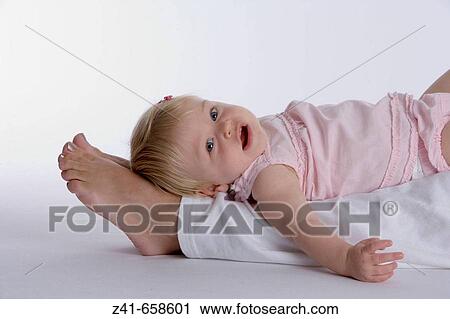 Blond little girl lying on her mothers legs View Large Photo Image Stock Image - Blond little girl lying on her mothers legs. Fotosearch