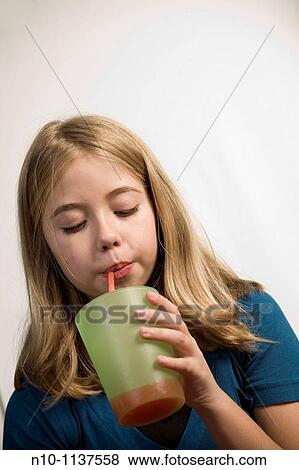Blond preteen girl drinking with a straw View Large Photo Image Stock Photo - Blond preteen girl drinking with a straw. Fotosearch