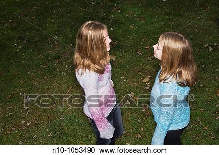 Blond preteen sisters in their backyard View Large Photo Image Stock Image - Blond preteen sisters in their backyard. Fotosearch
