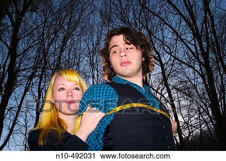 Blond teen girl using a tape measure to measure the chest of a teen boy View Large Photo Image Stock Image - Blond teen girl using a tape measure to measure the chest of a teen boy. Fotosearch
