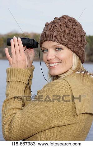 Blond woman in her 20's 30's using a pair of binoculars View Large Photo Image Stock Image - Blond woman in her 20's 30's using a pair of binoculars. Fotosearch