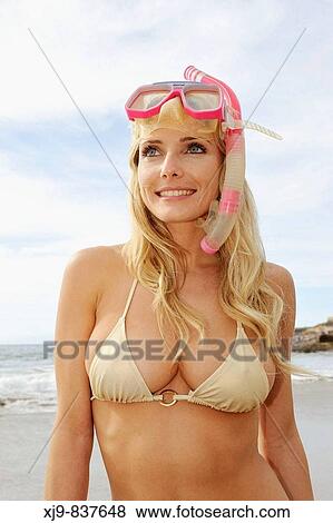 Stock Photo - Blonde diver looking the horizon in Tenerife south beach.. Fotosearch
