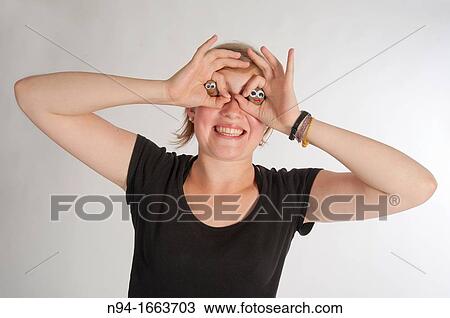 Blonde girl holding her hands in the shape of a pair of binoculars in front of her eyes. View Large Photo Image Stock Image - Blonde girl holding her hands in the shape of a pair of binoculars in front of her eyes.. Fotosearch