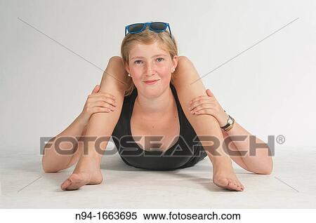 Stock Photography - Blonde girl lying on the floor simulating bodily contortions.. Fotosearch