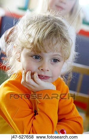 Stock Photo - blonde hair3 year old girl smiling off camera at nursery. Fotosearch