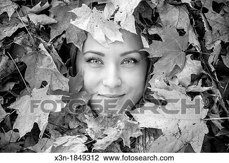 Blonde haired woman outdoors in leaf pile View Large Photo Image Stock Image - Blonde haired woman outdoors in leaf pile. Fotosearch