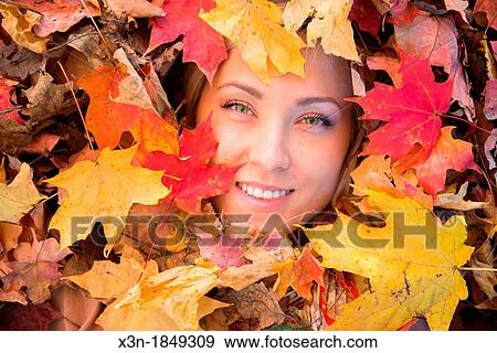 Blonde haired woman outdoors in leaf pile View Large Photo Image Stock Photo - Blonde haired woman outdoors in leaf pile. Fotosearch