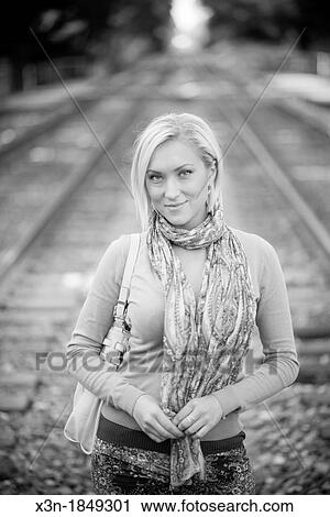 Blonde haired woman outdoors on train tracks View Large Photo Image Stock Image - Blonde haired woman outdoors on train tracks. Fotosearch