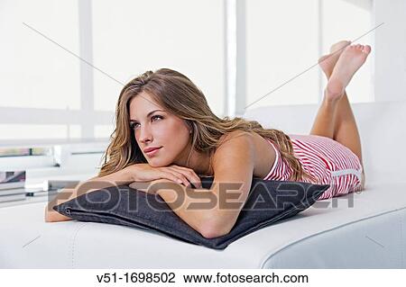 Blonde pensive woman lying down on the couch View Large Photo Image Stock Image - Blonde pensive woman lying down on the couch. Fotosearch
