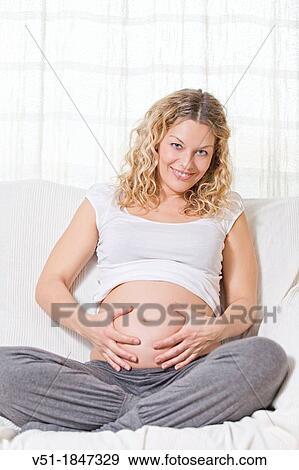 Blonde pregnant woman at sofa smiling at camera View Large Photo Image Stock Photo - Blonde pregnant woman at sofa smiling at camera. Fotosearch