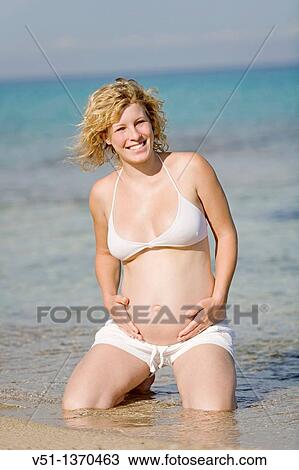 Stock Image - Blonde pregnant woman enjoying her pregnancy at the beach. Fotosearch