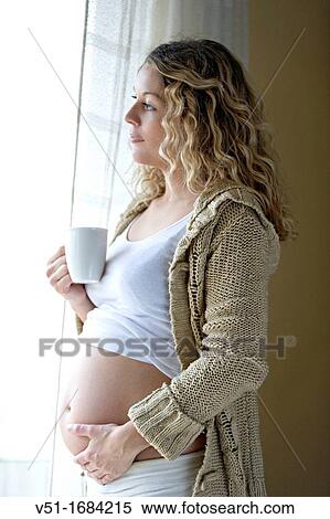 Blonde pregnant woman with drink looking at outside View Large Photo Image Stock Photography - Blonde pregnant woman with drink looking at outside. Fotosearch