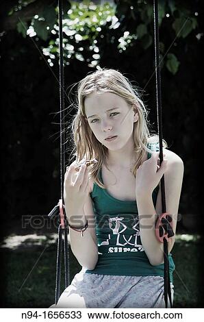 Blonde teen girl sitting on the swing with a snack. View Large Photo Image Stock Image - Blonde teen girl sitting on the swing with a snack.. Fotosearch