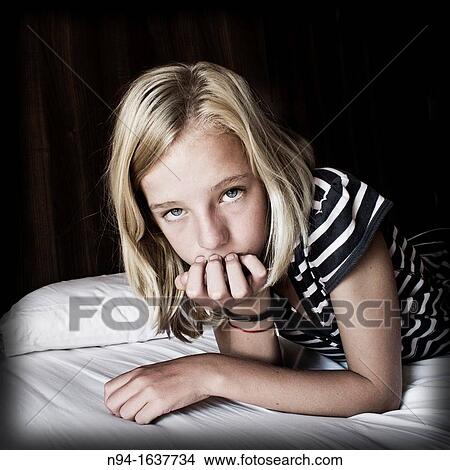 Blonde teen lying face down on the bed. View Large Photo Image Picture - Blonde teen lying face down on the bed.. Fotosearch