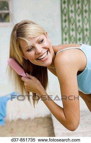 Blonde woman brushing her hair happy View Large Photo Image Stock Photography - Blonde woman brushing her hair happy. Fotosearch