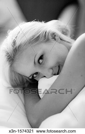 Stock Image - Blonde woman in bed, Black and white. Fotosearch