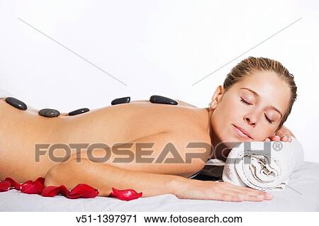 Blonde woman in massage with stones und petals View Large Photo Image Stock Image - Blonde woman in massage with stones und petals. Fotosearch