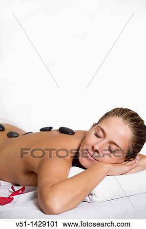 Blonde woman in massage with stones und petals View Large Photo Image Stock Image - Blonde woman in massage with stones und petals. Fotosearch