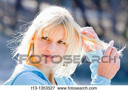 Blonde woman is hand-brushing her hair in a bright sunlight View Large Photo Image Stock Photo - Blonde woman is hand-brushing her hair in a bright sunlight. Fotosearch