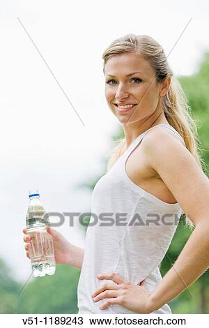 Blonde woman jogging in the park and drinking water View Large Photo Image Stock Image - Blonde woman jogging in the park and drinking water. Fotosearch