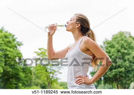 Blonde woman jogging in the park and drinking water View Large Photo Image Stock Photography - Blonde woman jogging in the park and drinking water. Fotosearch