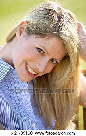 Blonde woman looking at camera smiling View Large Photo Image Stock Image - Blonde woman looking at camera smiling. Fotosearch
