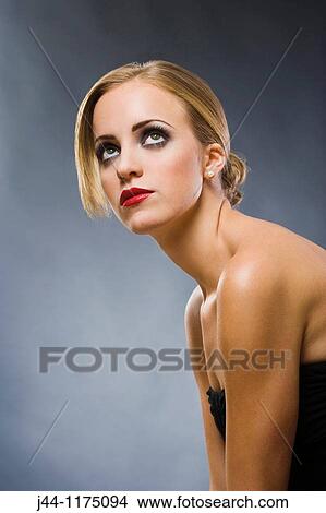Picture - Blonde woman looking up, portrait. Fotosearch