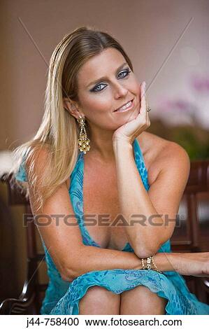 Blonde woman sitting on a chair, smiling, portrait View Large Photo Image Stock Image - Blonde woman sitting on a chair, smiling, portrait. Fotosearch