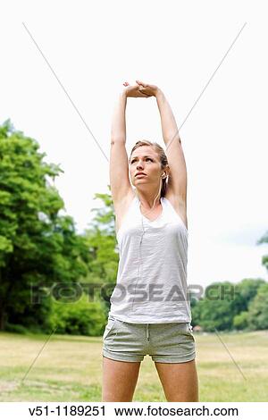 Blonde woman stretching in the park View Large Photo Image Stock Image - Blonde woman stretching in the park. Fotosearch