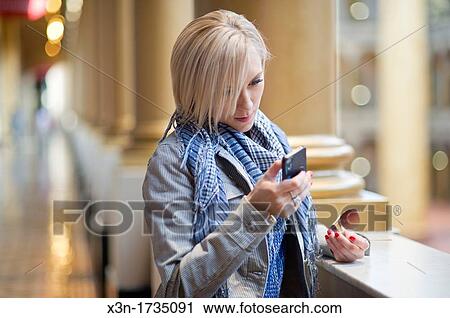 Blonde woman using smartphone View Large Photo Image Stock Image - Blonde woman using smartphone. Fotosearch
