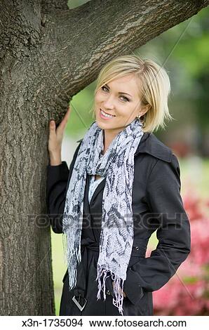 Blonde woman with green eyes against tree View Large Photo Image Picture - Blonde woman with green eyes against tree. Fotosearch