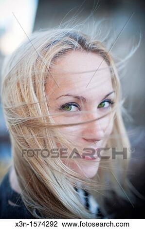 Stock Image - Blonde woman with hair blowing in wind. Fotosearch