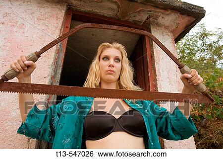 Blonde young housewife with an old saw View Large Photo Image Stock Photograph - Blonde young housewife with an old saw. Fotosearch