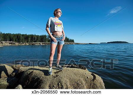 Stock Image - Blonde young woman on beach in Maine.. Fotosearch
