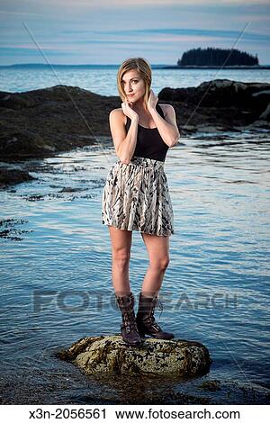 Stock Image - Blonde young woman on beach in Maine.. Fotosearch
