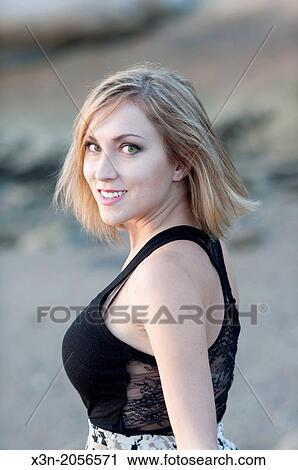 Stock Image - Blonde young woman on beach in Maine.. Fotosearch