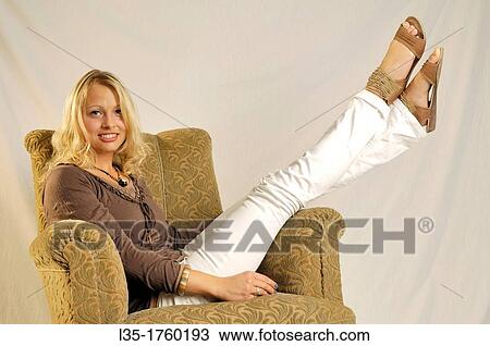 Blonde young woman sitting on couch View Large Photo Image Stock Image - Blonde young woman sitting on couch. Fotosearch