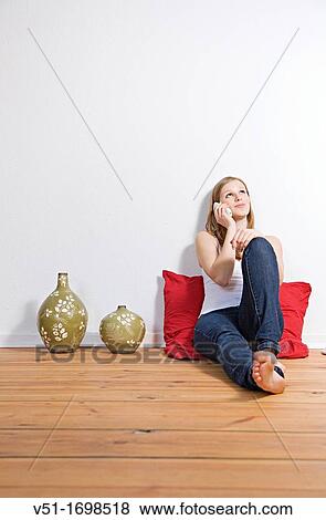 Blonde young woman talking on the phone at home View Large Photo Image Stock Photo - Blonde young woman talking on the phone at home. Fotosearch