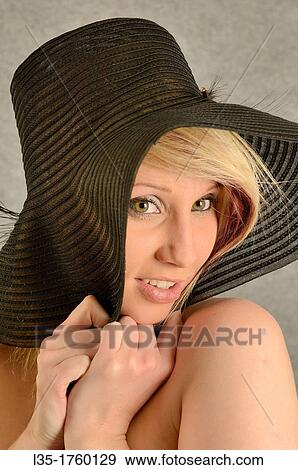 Stock Photo - Blonde young woman wearing a hat. Fotosearch