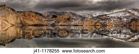 Blue Lake reflections of clay cliffs after winter storm and snowfall, St Bathans, Central Otago, New Zealand. View Large Photo Image Stock Photography - Blue Lake reflections of clay cliffs after winter storm and snowfall, St Bathans, Central Otago, New Zealand.. Fotosearch