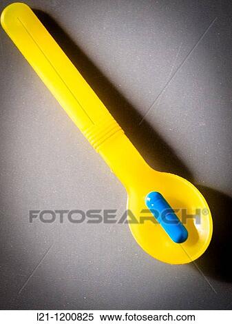 Blue pill in a yellow spoon on gray background View Large Photo Image Stock Photography - Blue pill in a yellow spoon on gray background. Fotosearch