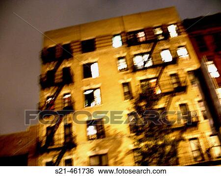 Stock Photograph - Blurred apartment building in New York's East Village. The image was captured at night, and has a ghostly feel. USA.. Fotosearch